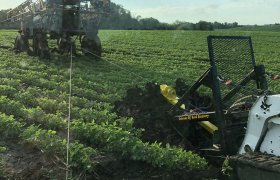 Portable winch machine being used to pull farm equipment from a field