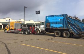 Bock's Service heavy-duty tow truck pulling a garbage truck