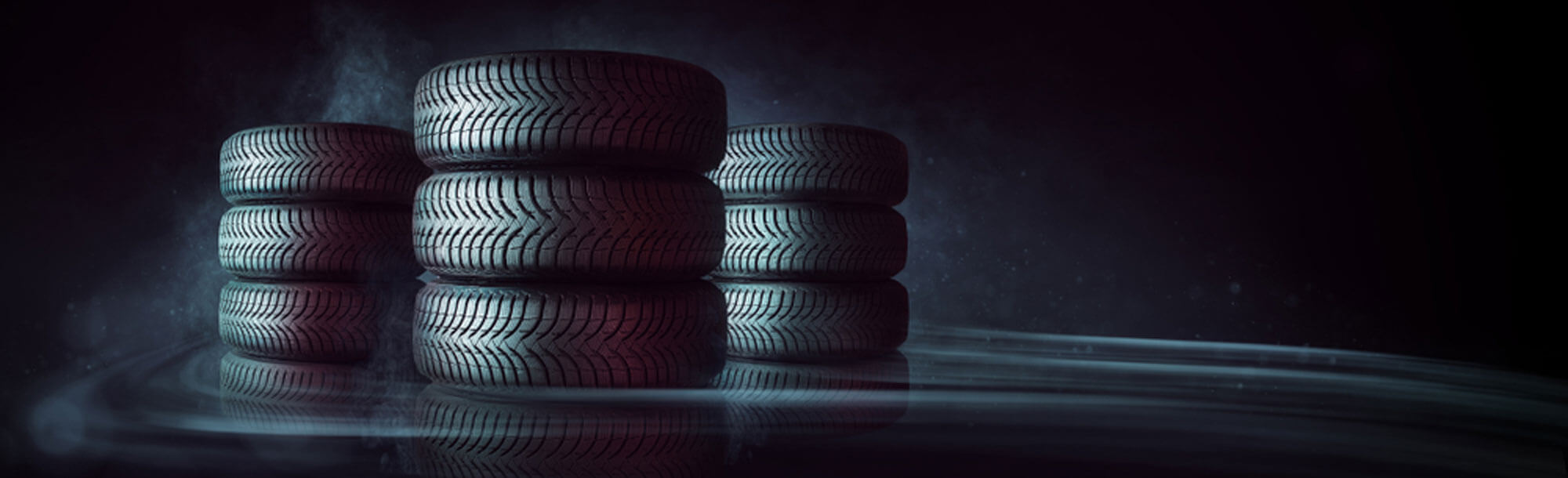 Three stacks of tires against a black background